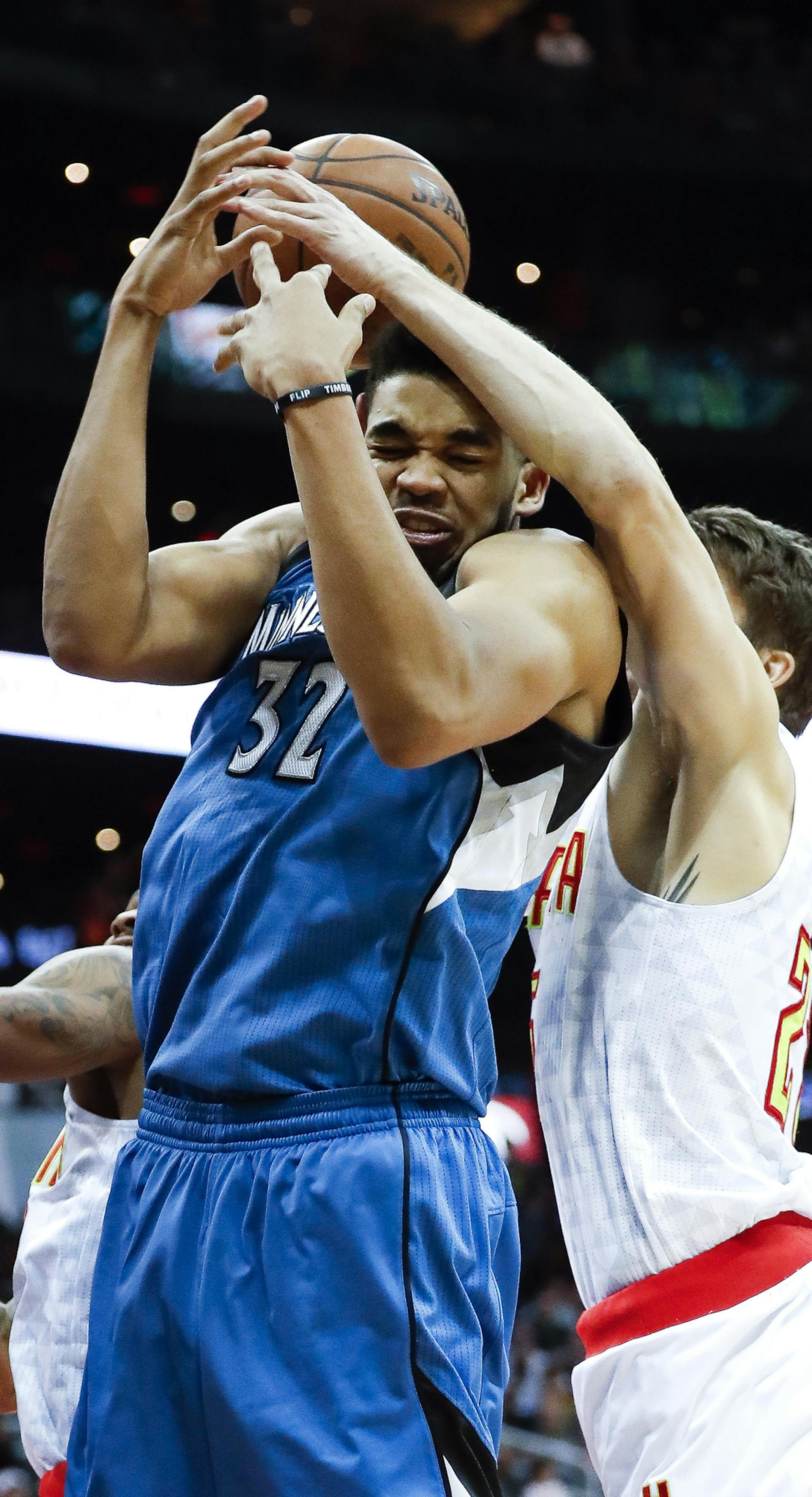 Minnesota Timberwolves center Karl-Anthony Towns (32) and Atlanta Hawks guard Kyle Korver (26) battle for a rebound as Minnesota forward Andrew Wiggins (22) looks on at left in the second half of an NBA basketball game Wednesday, Dec. 21, 2016, in Atlanta. Minnesota won 92-84. (AP Photo/John Bazemore)