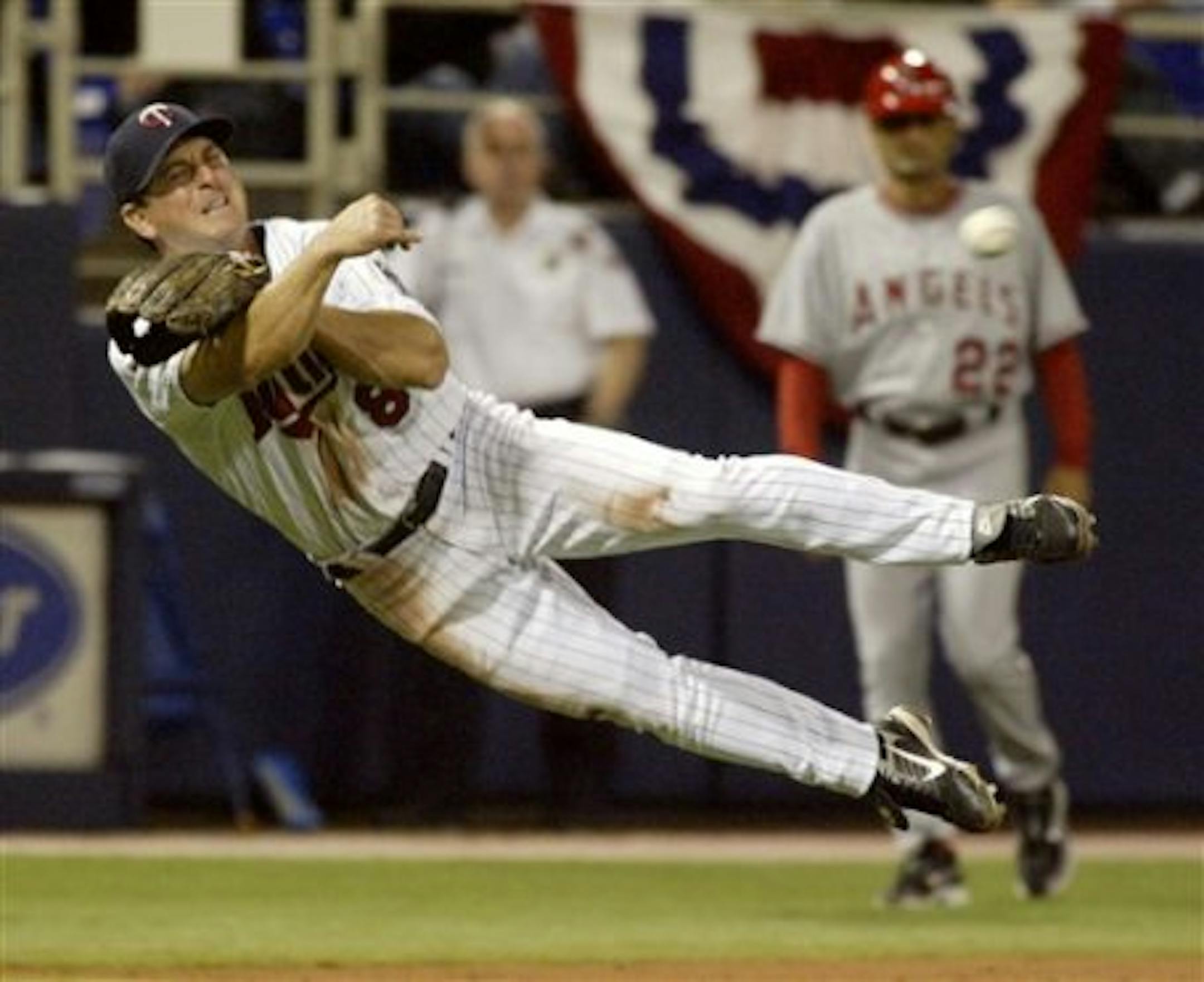 Minnesota Twins third baseman Nick Punto (8) throws tho first to force the Los Angeles Angels Howie Kendrick during the ninth inning of a baseball game Wednesday, April 2, 2008, in Minneapolis. The Angels won, 1-0. AP Photo/Paul Battaglia)