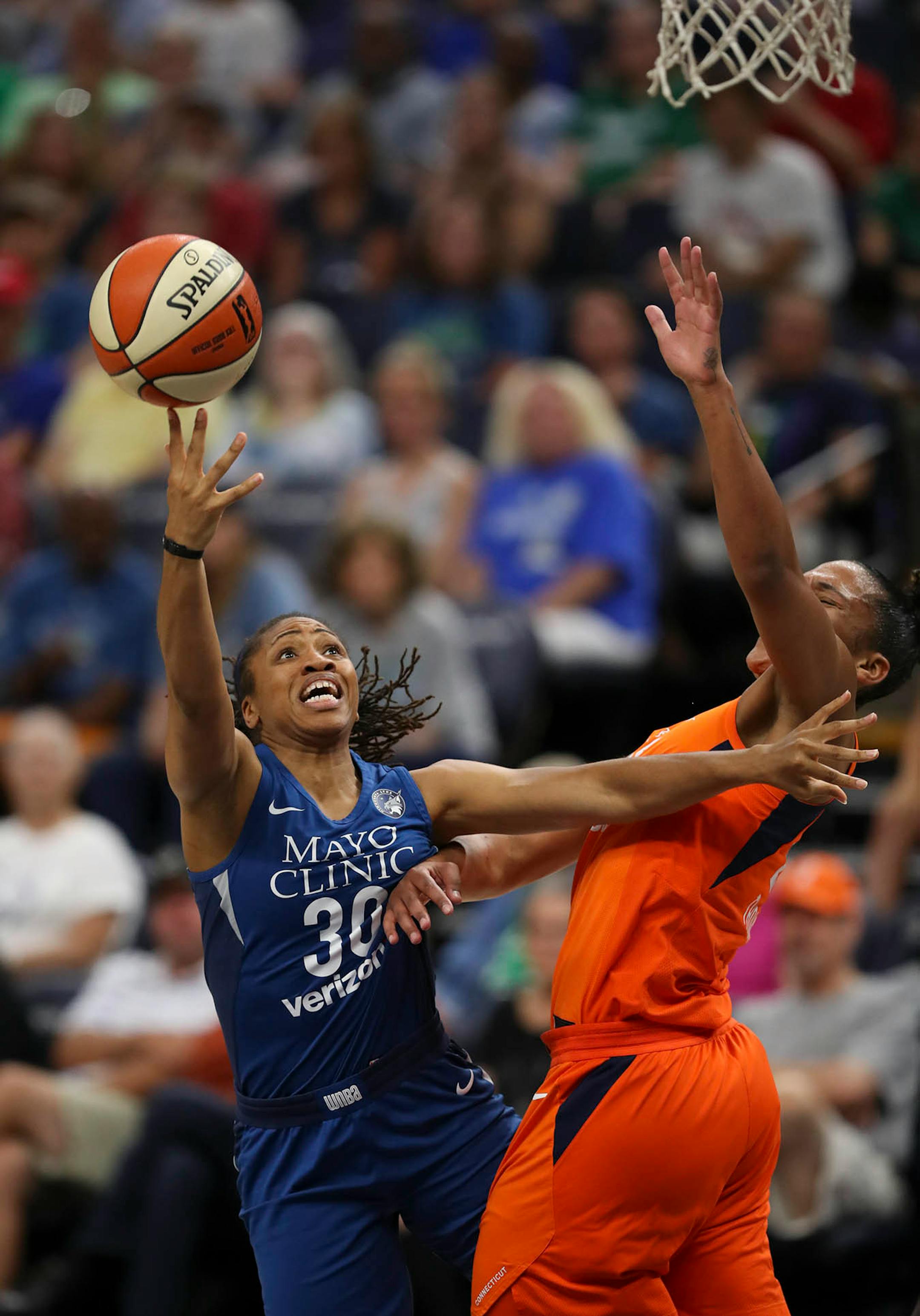 Minnesota Lynx guard Tanisha Wright (30) earned an offensive foul when she pushed aside Connecticut Sun forward Alyssa Thomas (25) to take a shot in the first half.