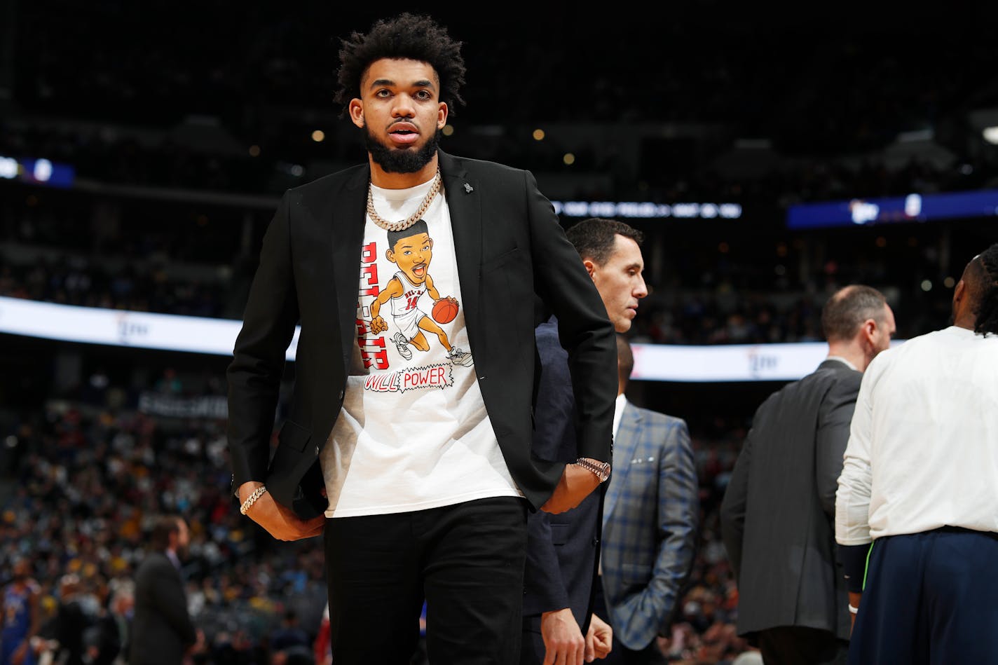 Minnesota Timberwolves center Karl-Anthony Towns takes a seat on the bench in the second half of an NBA basketball game against the Denver Nuggets, Friday, Dec. 20, 2019, in Denver. Towns, who usually starts for the Timberwolves, did not play because of an ankle injury. (AP Photo/David Zalubowski)