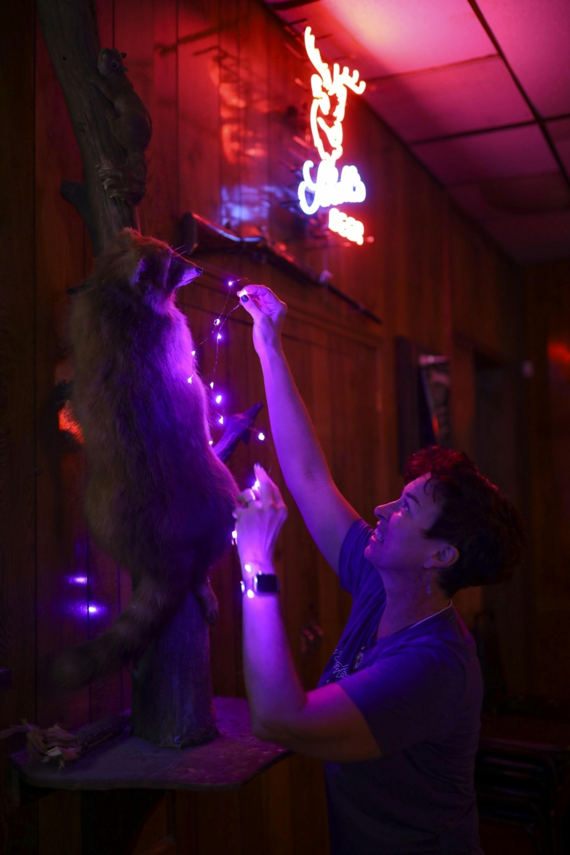 Heidi Vader adorned a stuffed raccoon with purple lights as she finished preparations for the "Free Urself Dance Party" Wednesday night at Lee's Liquor Lounge.