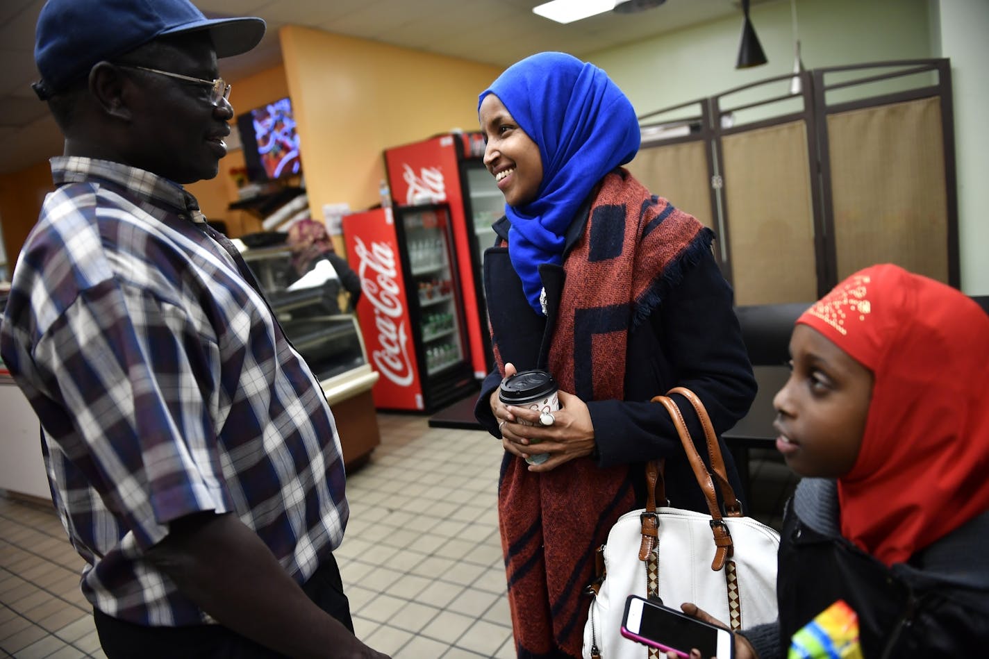 Ilhan Omar, state representative candidate for District 60B, spoke to a supporter John Kamsin after granting an interview to the Star Tribune and eating dinner at Bir'raa restaurant in the Seward neighborhood Tuesday night.