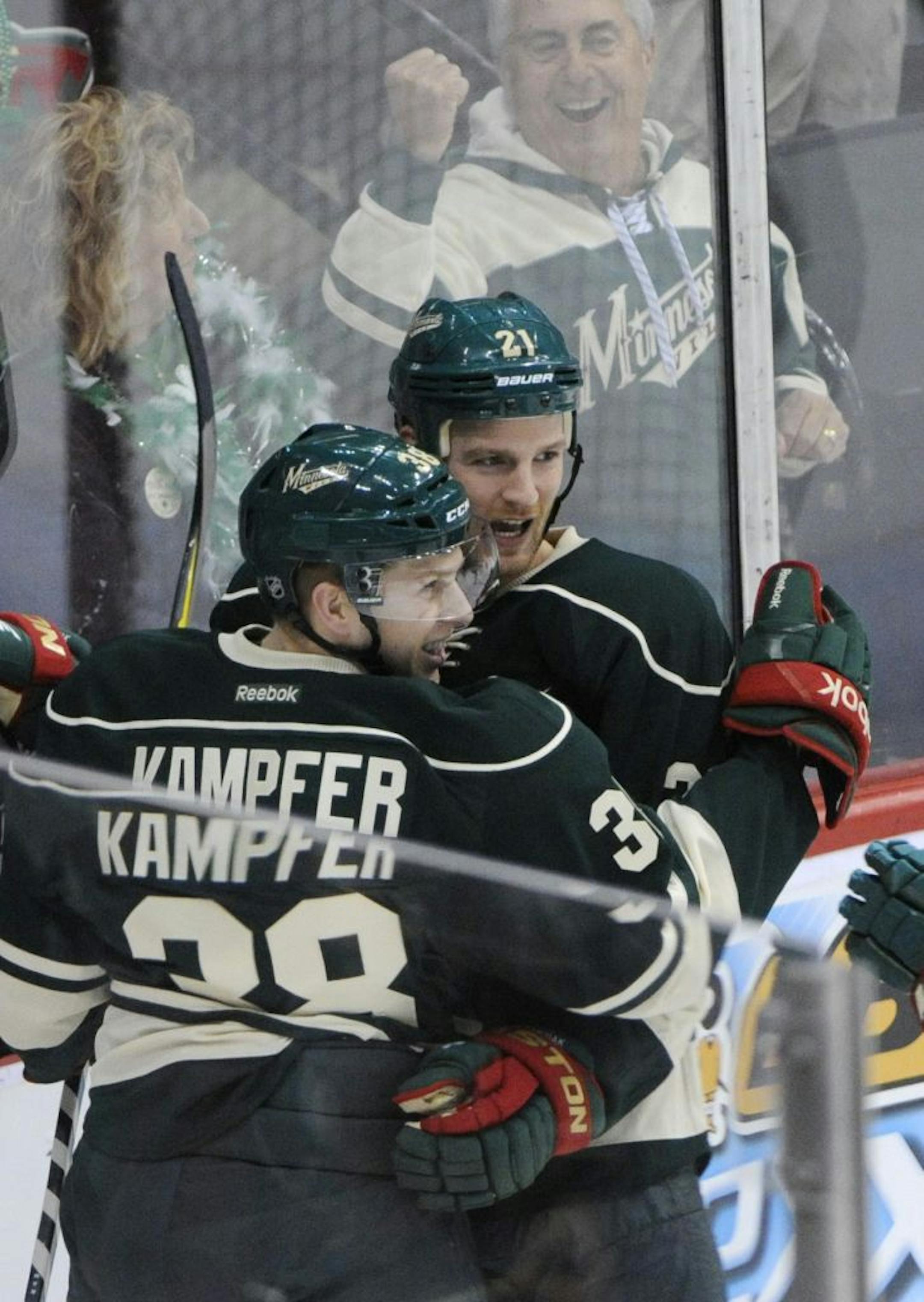 Minnesota Wild's Steven Kampfer, left, and Kyle Brodziak in the first period of an NHL hockey game against the Carolina Hurricanes Saturday, March 17, 2012, in St. Paul, Minn.
