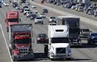 FILE - In this Wednesday, Aug. 24, 2016, file photo, truck and automobile traffic mix on Interstate 5, headed north through Fife, Wash., near the Port