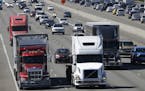 FILE - In this Wednesday, Aug. 24, 2016, file photo, truck and automobile traffic mix on Interstate 5, headed north through Fife, Wash., near the Port