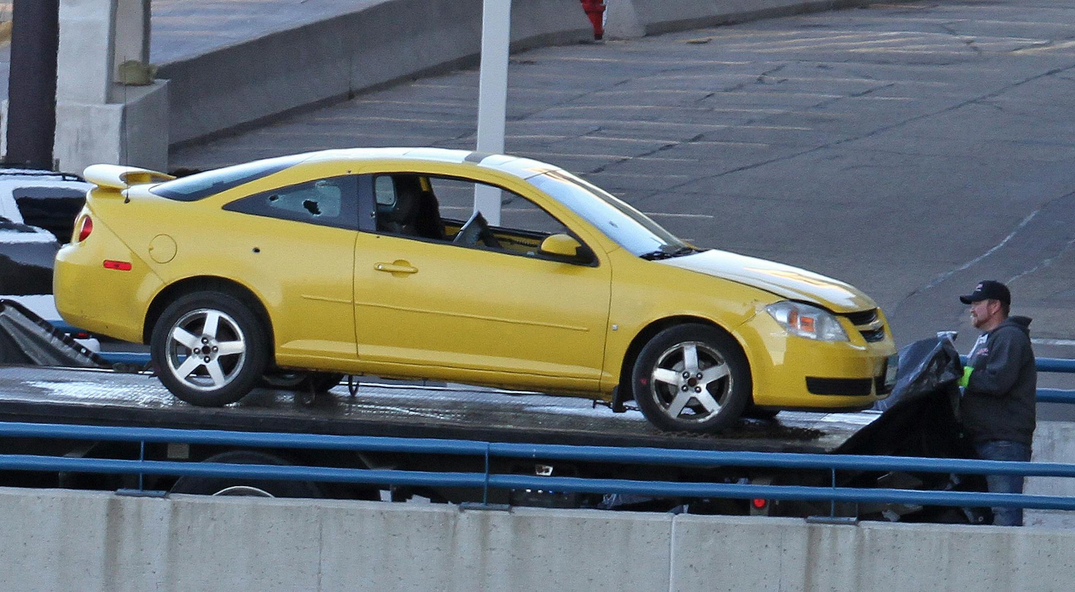 At Minneapolis-St Paul airport, tow operators load a car involved in an incident with shots fired by police.