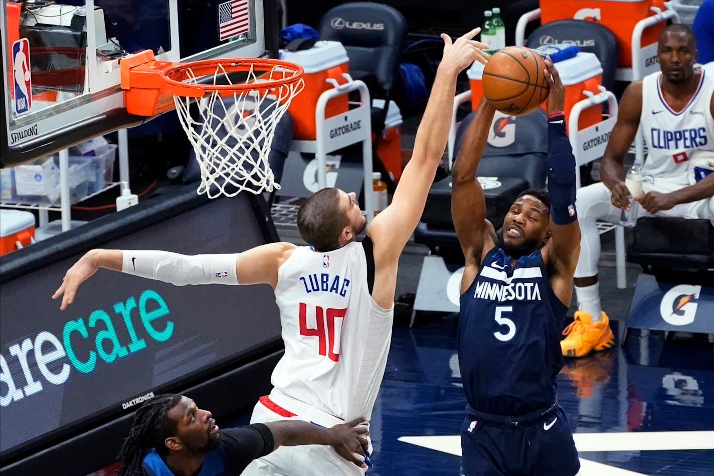 Los Angeles Clippers' Ivica Zubac (40) tries to knock the ball away from Minnesota Minnesota Timberwolves' Malik Beasley (5) during the first half of an NBA basketball game Wednesday, Feb. 10, 2021, in Minneapolis. (AP Photo/Jim Mone)