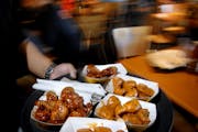 A platter of Buffalo Wild Wings is served to lunch-hour customers at the Buffalo Wild Wings restaurant in Oakdale, Minn.