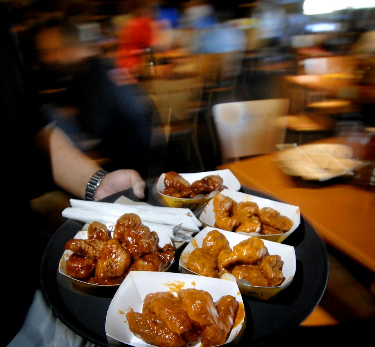 A platter of Buffalo Wild Wings is served to lunch-hour customers at the Buffalo Wild Wings restaurant in Oakdale, Minn.