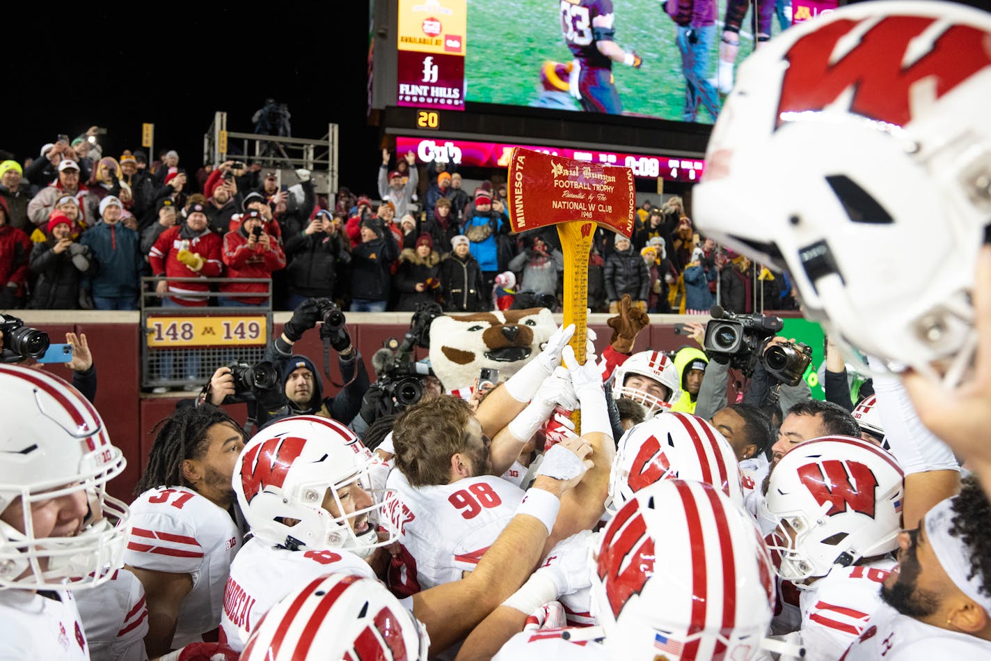 The Wisconsin football team celebrates with Paul Bunyan's Axe after defeating Minnesota 28-14 Saturday, Nov. 25, 2023, at Huntington Bank Stadium in Minneapolis, Minn. ]