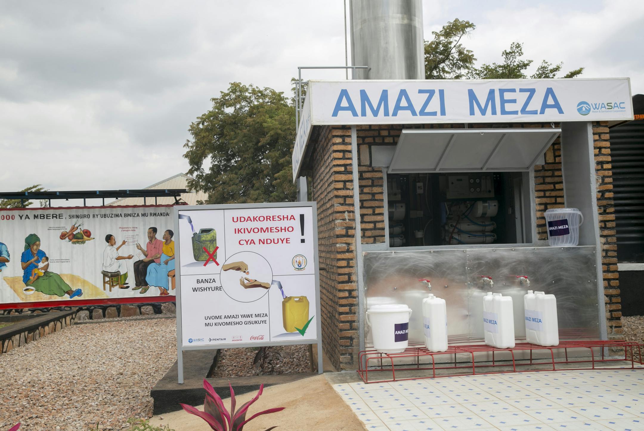 1) The water filtration equipment that Pentair donated to the village of Ruhunda, Rwanda and its new Ekocenter. Pentair of Golden Valley, MN. donated the water filtration equipment that will serve 20,000 liters of fresh water a day to 25,000 local residents in the town of Ruhunda, Rwanda. 2) two entrepreneurs will own and run the water filtration system and the other features inside the Ekocenter kiosk. Coca-Cola developed the Ekocenter as a way to start micro-enterprise businesses in rural area
