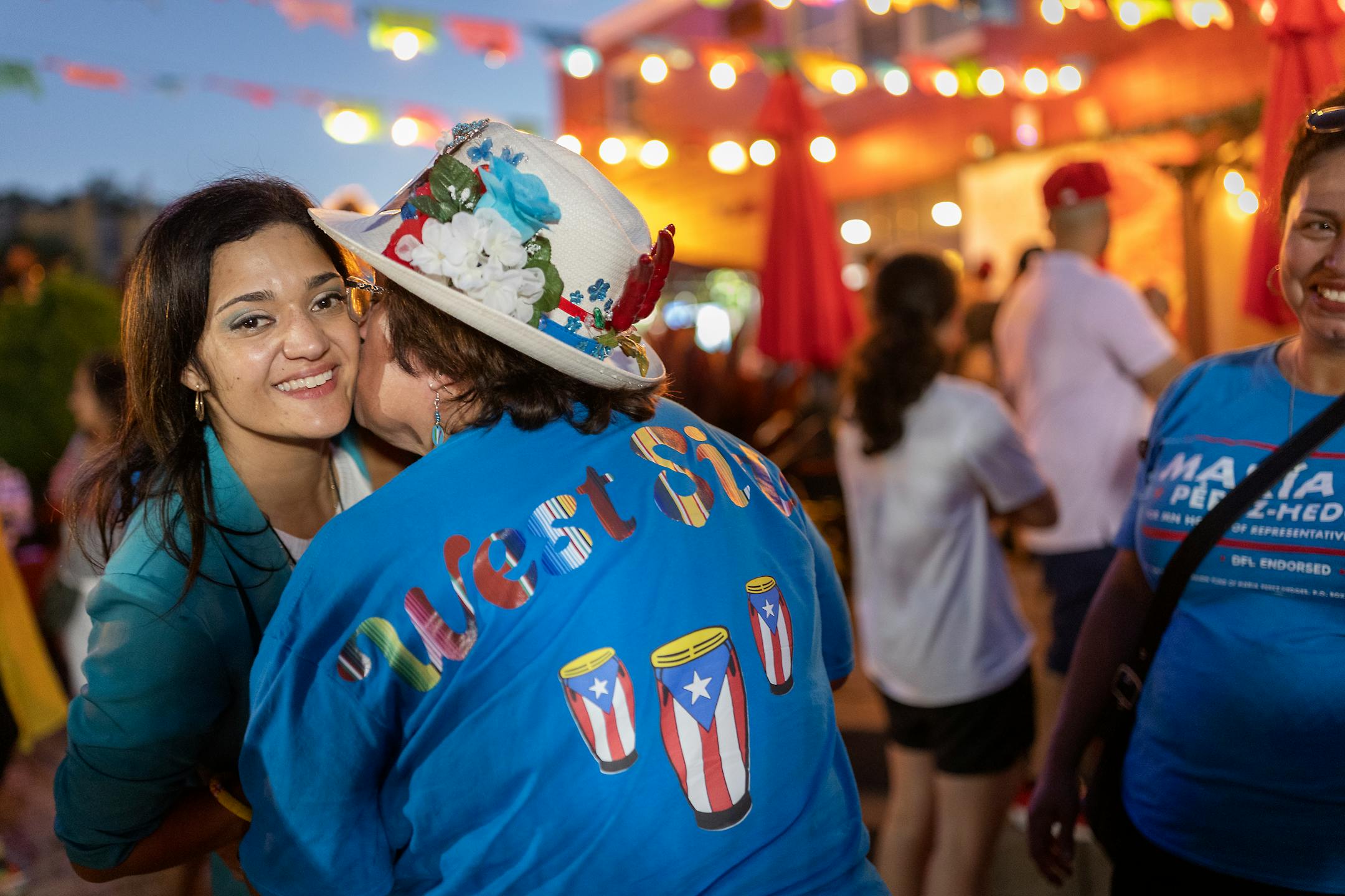 Maria Isa Perez-Hedges gets a kiss from Debbie Luna after as she celebrates her win at a gathering at El Burrito Mercado in St. Paul.