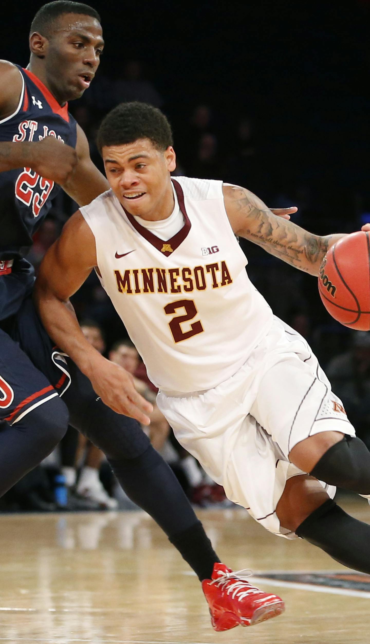 Minnesota guard Nate Mason (2) drives against St. John's guard Rysheed Jordan (23) on his way toward the basket in the first half of an NCAA college basketball game in New York, Wednesday, Nov. 26, 2014. (AP Photo/Kathy Willens)