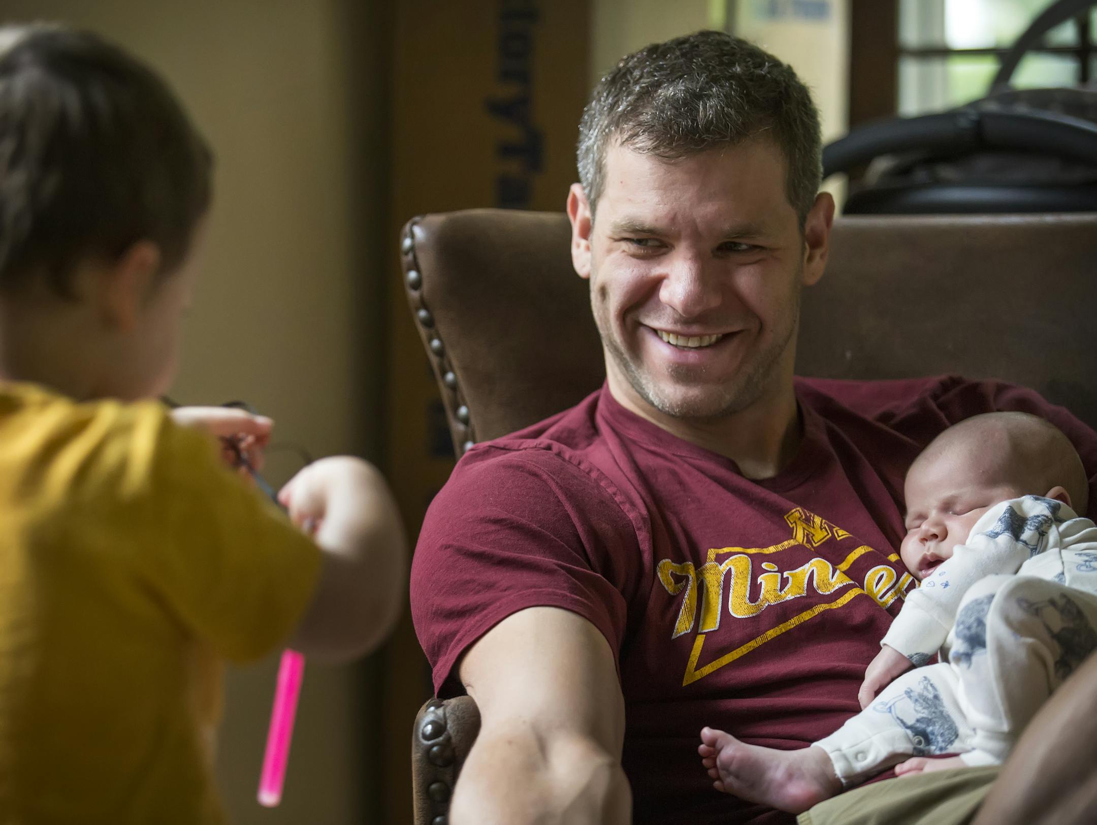 Minnesota swimmer David Plummer is juggling the dream of being and elite Olympic athlete and being a father and husband. Here, Plummer holds his newborn son Ricky as 2-year-old Will shows him a new toy. ] brian.peterson@startribune.com Minneapolis, MN - 06/13/2016
