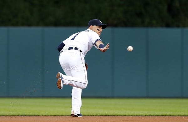 Detroit Tigers shortstop Jose Iglesias flips the ball to second base to start a double play against the Minnesota Twins in the first inning during a b