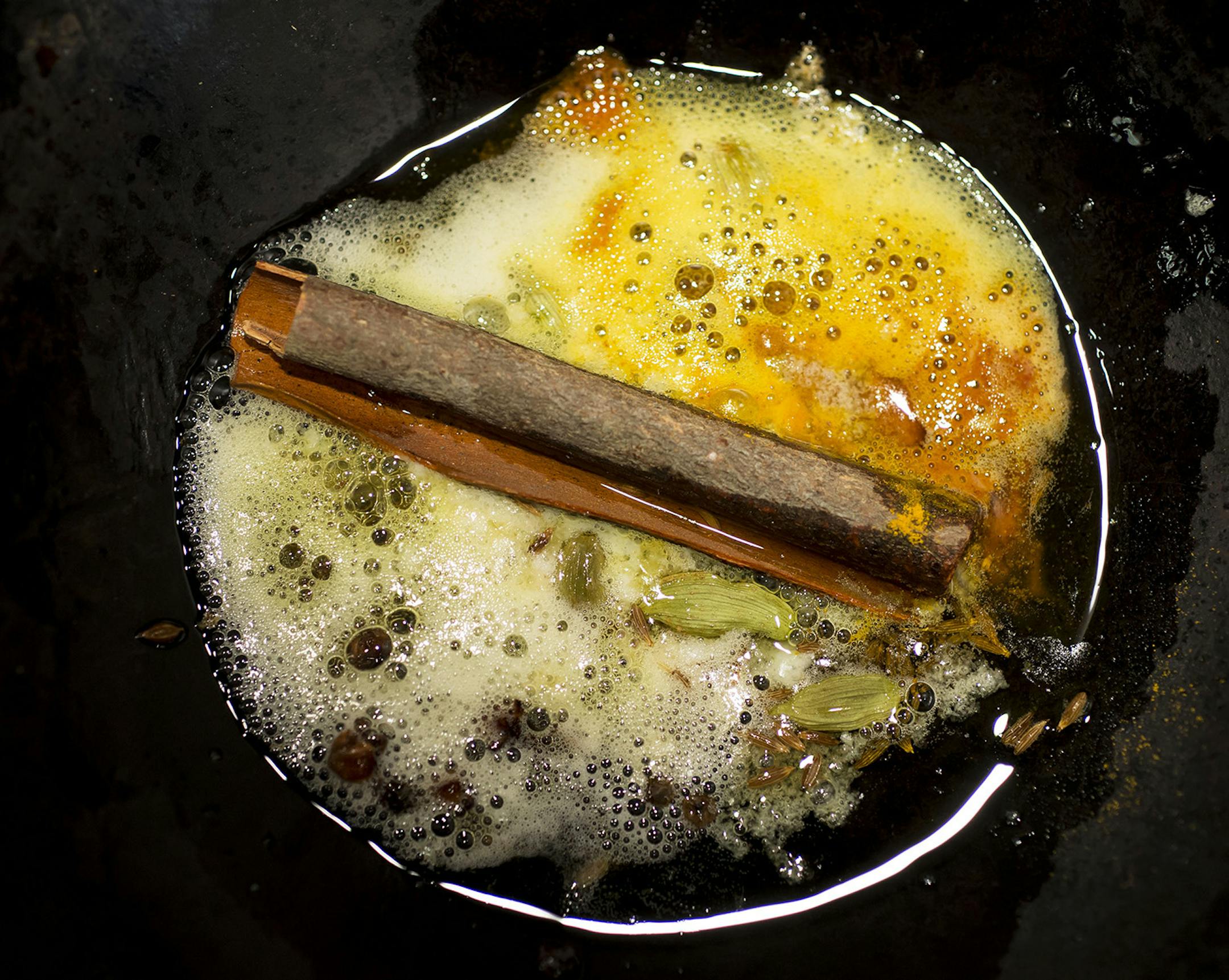 Cumin seeds, cardamom and cinnamon cook in ghee to make tadka, a common technique in Indian cooking and useful in flavoring bland dishes of dal, in New York, Feb. 25, 2014. Dal, made from dried beans, is a versatile staple in India, found on nearly every table every day, rich or poor. (Karsten Moran/The New York Times) ORG XMIT: XNYT85