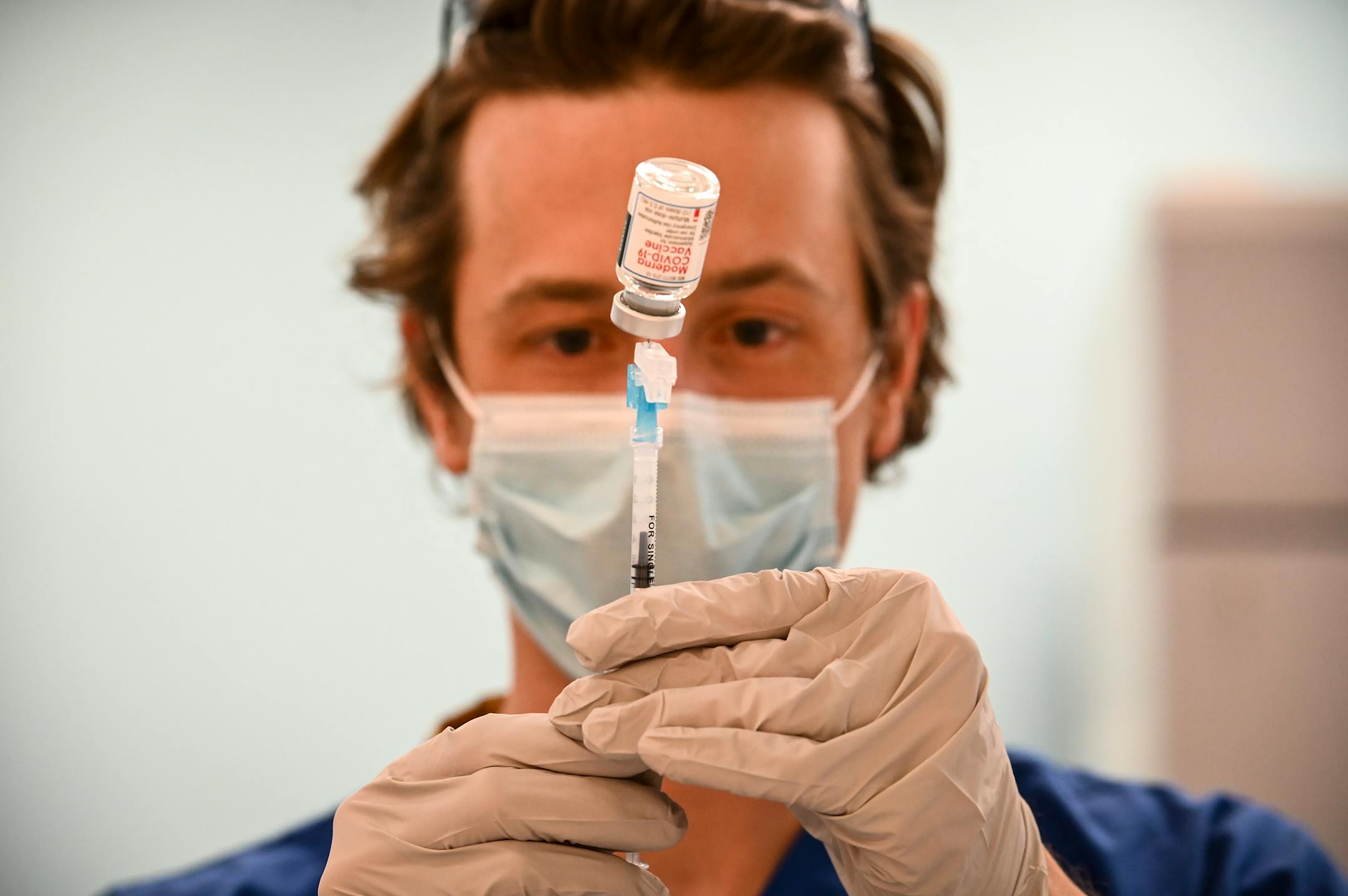 Kirk Randall, a nurse with Blue Cross and Blue Shield of Minnesota, filled a syringe with a dose of the Moderna COVID-19 vaccine.