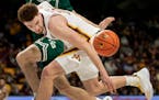 Gophers forward Jamison Battle (10) fought for a loose ball in the team’s last game against Wisconsin Green Bay.