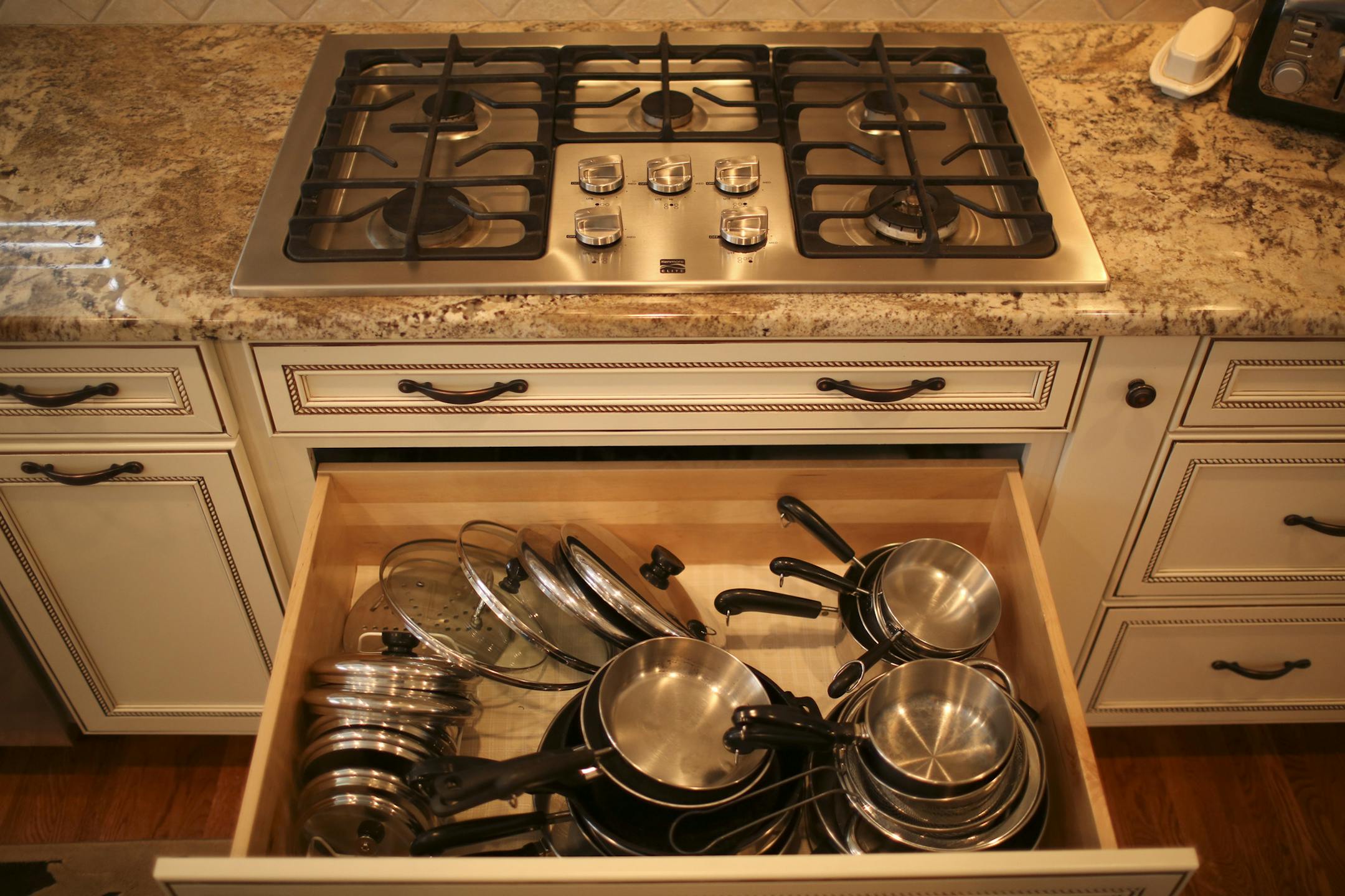 Pat and Gene Swiridow's 1970s rambler remodel and addition will be open for tours on the 2013 Remodelers Showcase, March 22-24. Their kitchen and hearth room addition were photographed Monday afternoon, March 11, 2013 in Eagan, Minn. One thing Pat Swiridow was sure she wanted in her new kitchen was lots of drawers for storage, such as this one under the countertop cooking surface that holds her pot and pans. ] JEFF WHEELER ‚Ä¢ jeff.wheeler@startribune.com