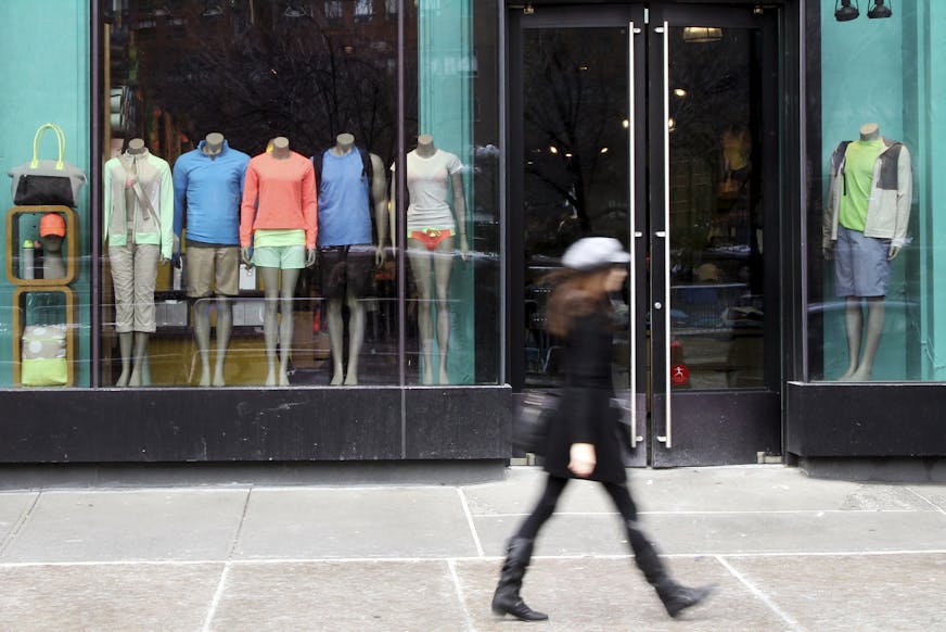FILE - This March 19, 2013 file photo shows a pedestrian walking past the Lululemon Athletica store at Union Square in New York. Lululemon yanked its popular black yoga pants from store shelves after it found that the sheer material used was revealing too much of its loyal customers. (AP Photo/Mary Altaffer, File)