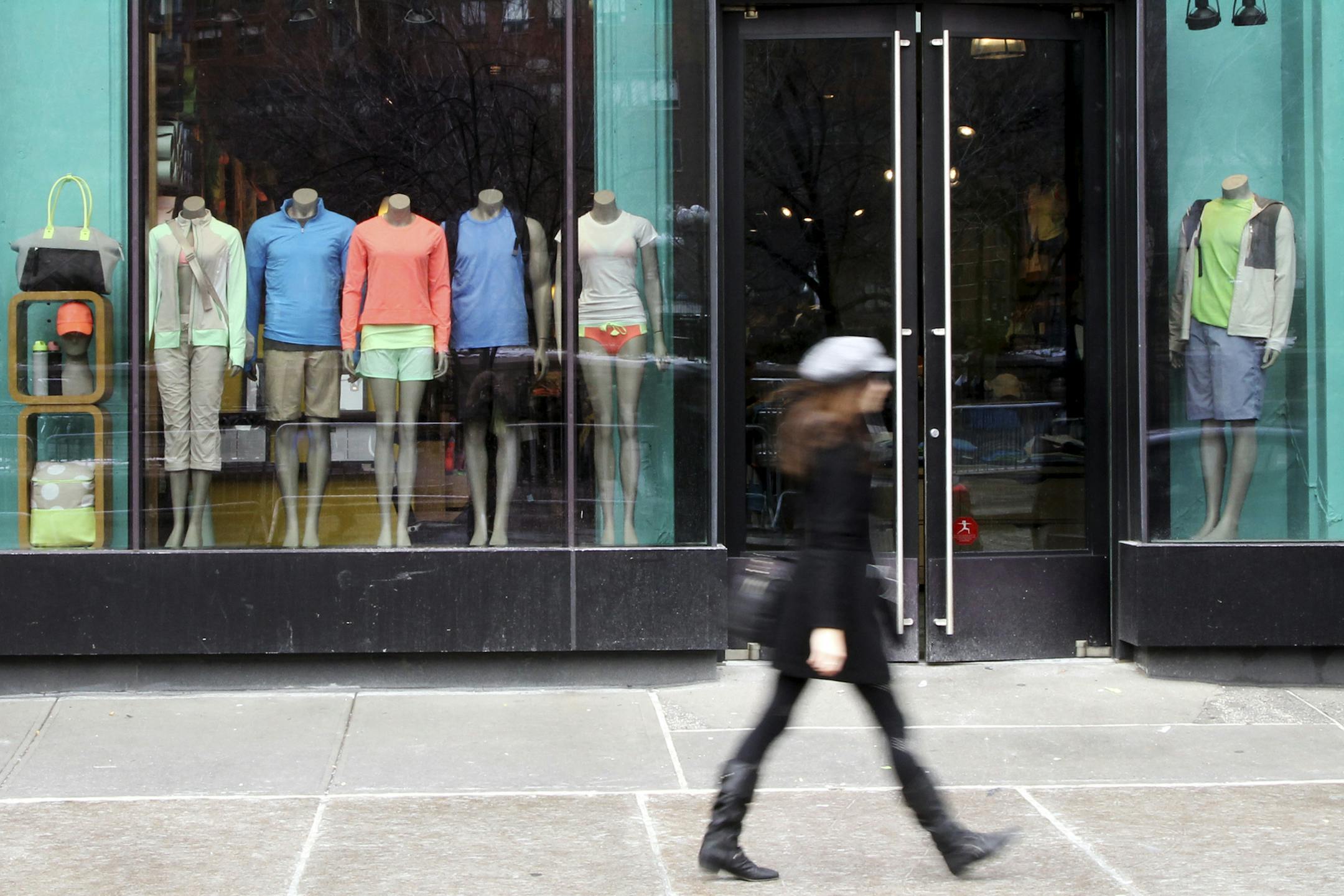 FILE - This March 19, 2013 file photo shows a pedestrian walking past the Lululemon Athletica store at Union Square in New York. Lululemon yanked its popular black yoga pants from store shelves after it found that the sheer material used was revealing too much of its loyal customers. (AP Photo/Mary Altaffer, File)