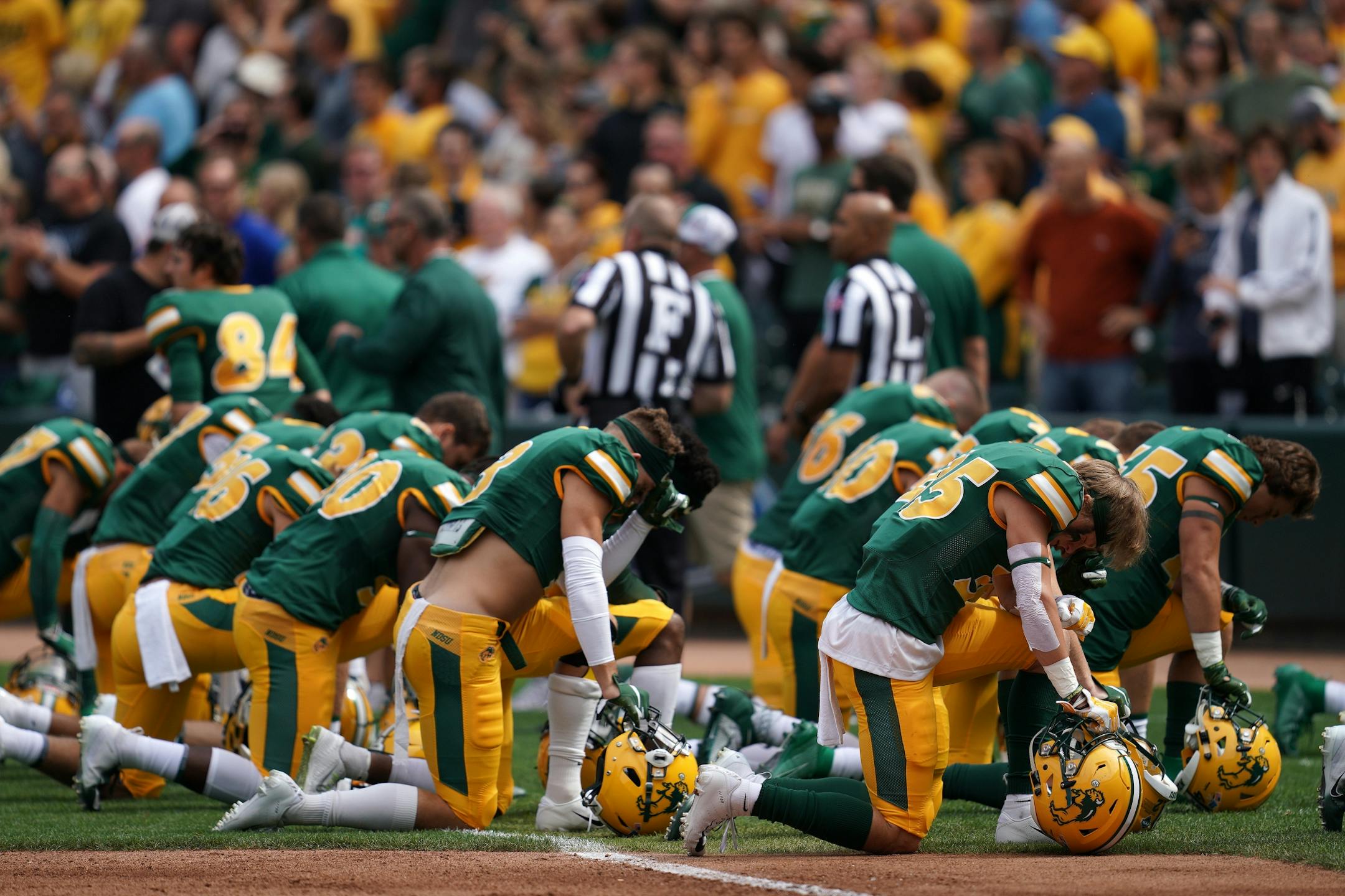 North Dakota State Bison players knelt in the end zone as they took the field before Saturday's game against the Butler Bulldogs.