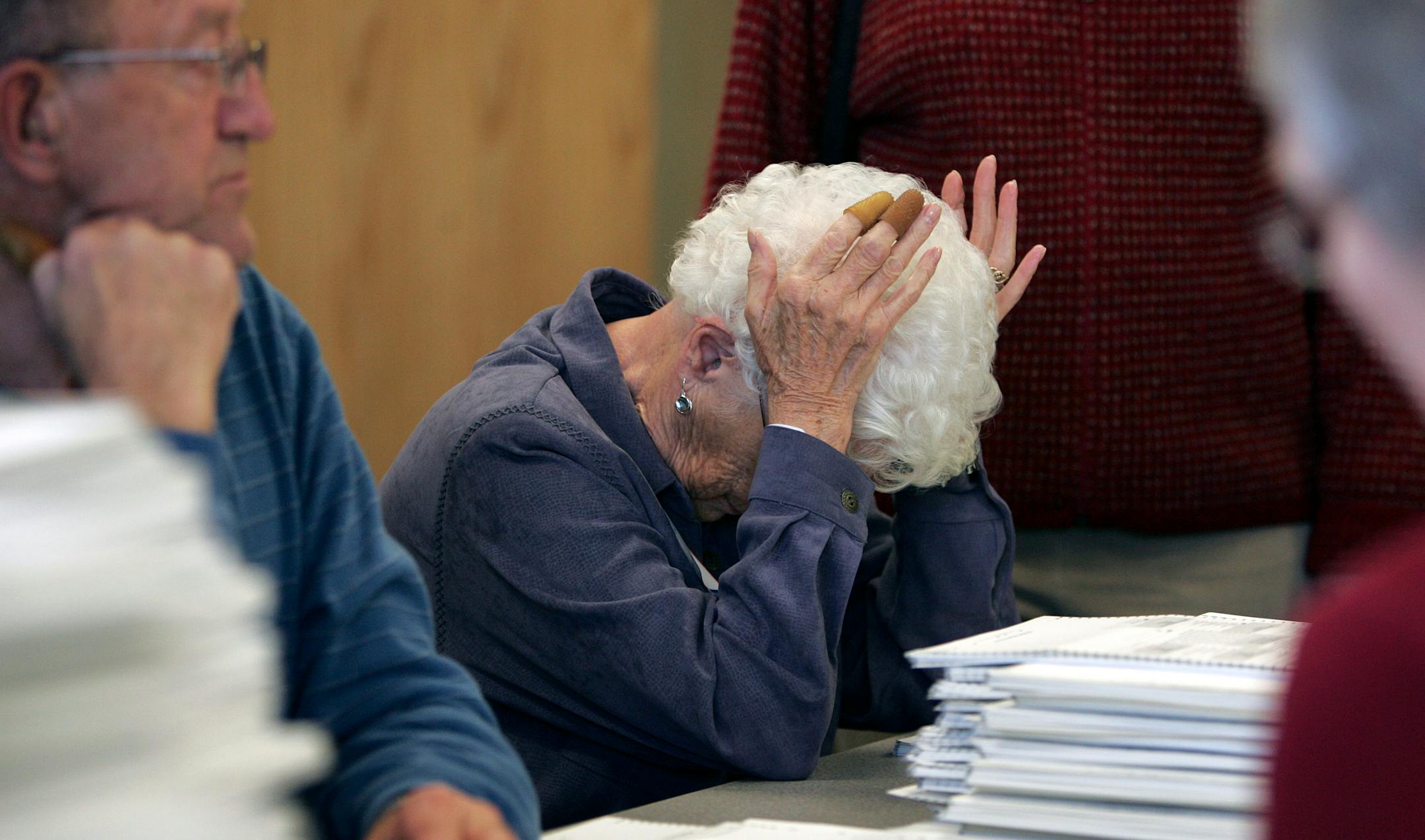 Election judge Ann Berres, center, reacted to news that she and those working at her table would need to count all the ballots for a second time.