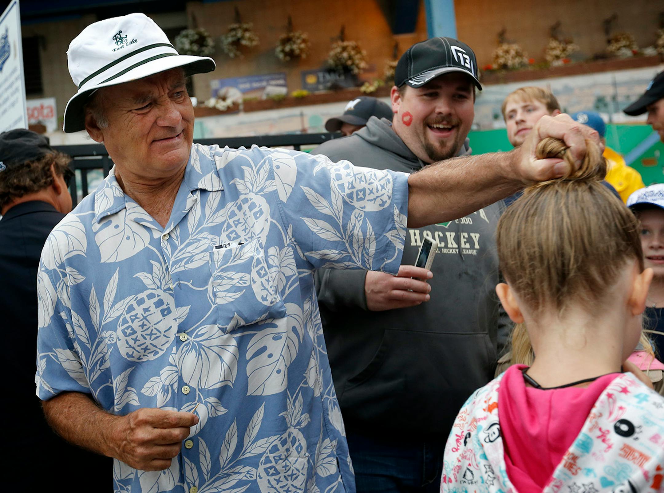 While taking tickets at the entry gate Bill Murray stopped to grab the hair bun of Audrey Beffel, 9, of Annandale. ] CARLOS GONZALEZ cgonzalez@startribune.com - August 28, 2014, St. Paul, Minn., Midway Stadium, St. Paul Saints baseball vs. Winnipeg - Final Saints game at Midway Stadium
