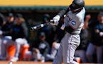 The Marlins' Nick Gordon hits a single against the Athletics during the ninth inning Sunday.