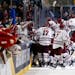 Massachusetts players celebrate a 4-3 overtime victory over Denver in the semifinals of the Frozen Four NCAA men's college hockey tournament Thursday,