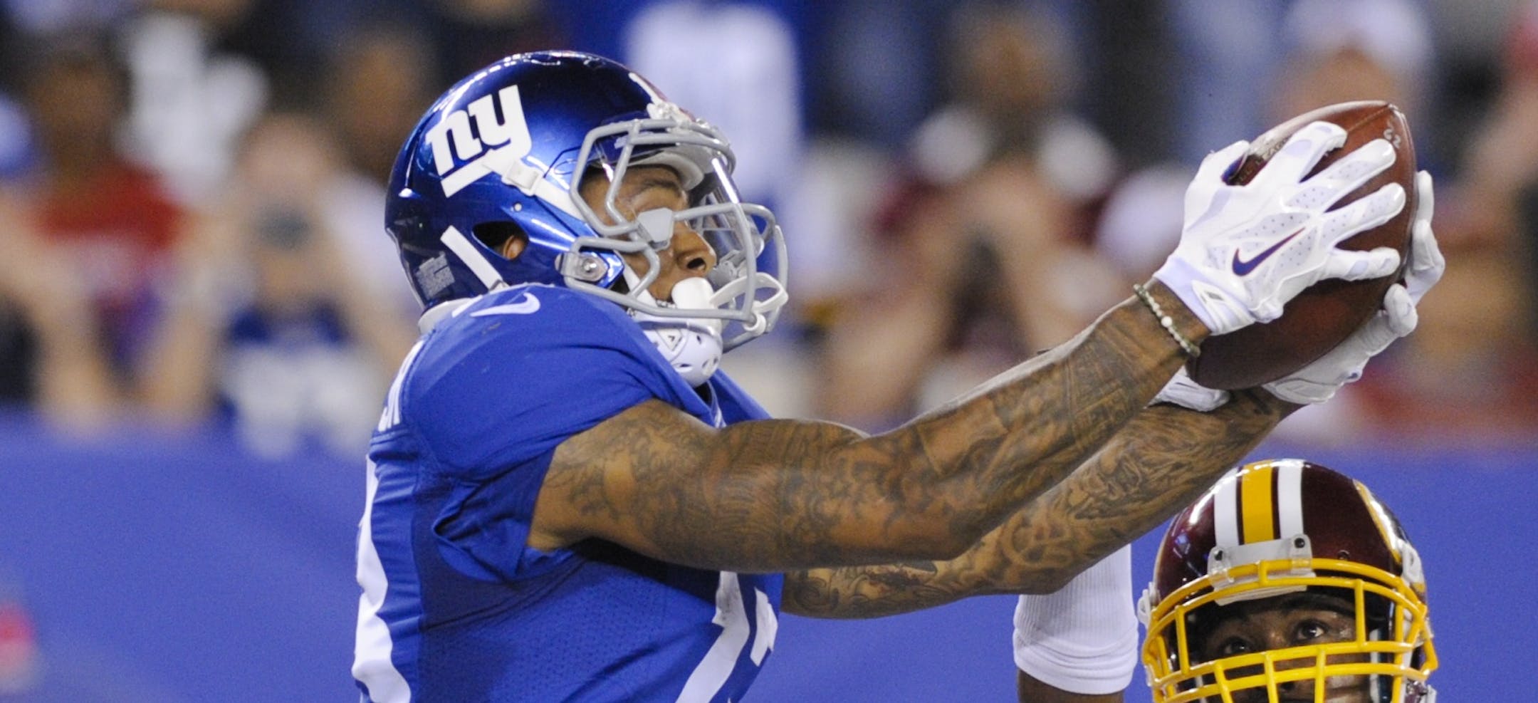 New York Giants wide receiver Odell Beckham (13) catches a pass for a touchdown in front of Washington Redskins' Bashaud Breeland (26) during the second half an NFL football game Thursday, Sept. 24, 2015, in East Rutherford, N.J. (AP Photo/Bill Kostroun)