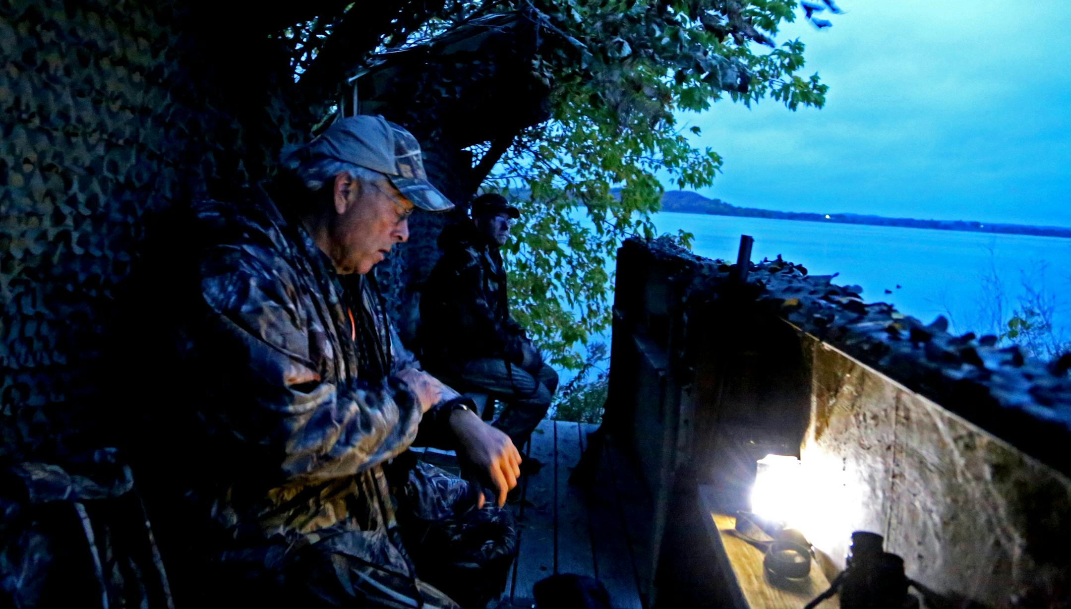 Dan Gahlon, left, of Delano, checks his watch just prior to shooting time Friday morning at Lake Christina near Ashby, Minnesota, about 30 miles from Alexandria, Minn. Jon Schneider of Ducks Unlimited is at right. Schneider, along with the DNR and especially nearby residents, helped spearhead the recent restoration of Lake Christina by controlling its water level and ridding it of many of its carp.