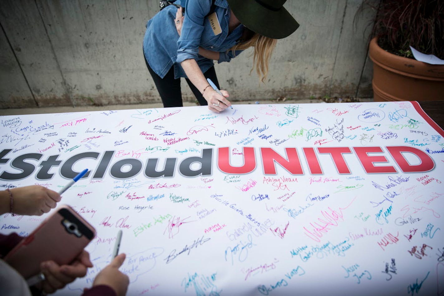 A woman signed a banner carried at a unity rally at St. Cloud State University.