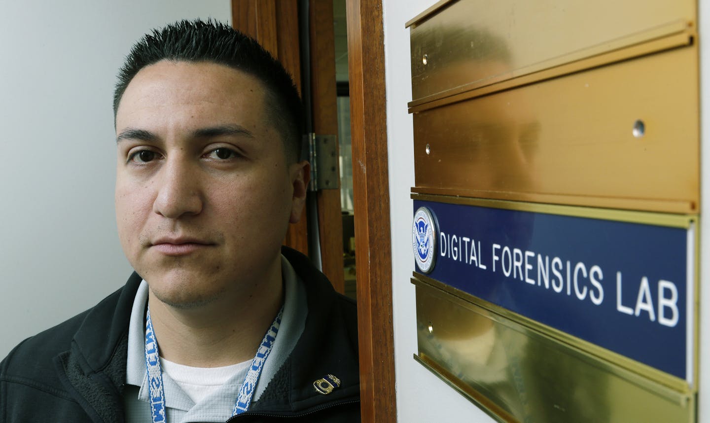 Army Staff Sgt. Oskar Zepeda at the entrance to a Digital Forensics Lab at an Immigration and Customs Enforcement field office in Seattle, where he is serving a one-year internship.