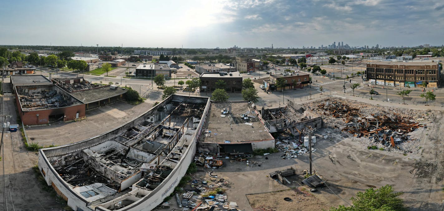 A wide angle panorama of Buildings that were burned during the unrest after the killing of George Floyd remain a pile of rubble at the intersection of 27th Ave and Lake Street in Minneapolis. While a handful of property owners have started rebuilding in the Twin Cities, most projects remain stuck in neutral because of the high cost of demolishing riot-damaged buildings and hauling away the debris. Contractors are offering to do the work for $200,000 to $300,000, which is not much less than the b