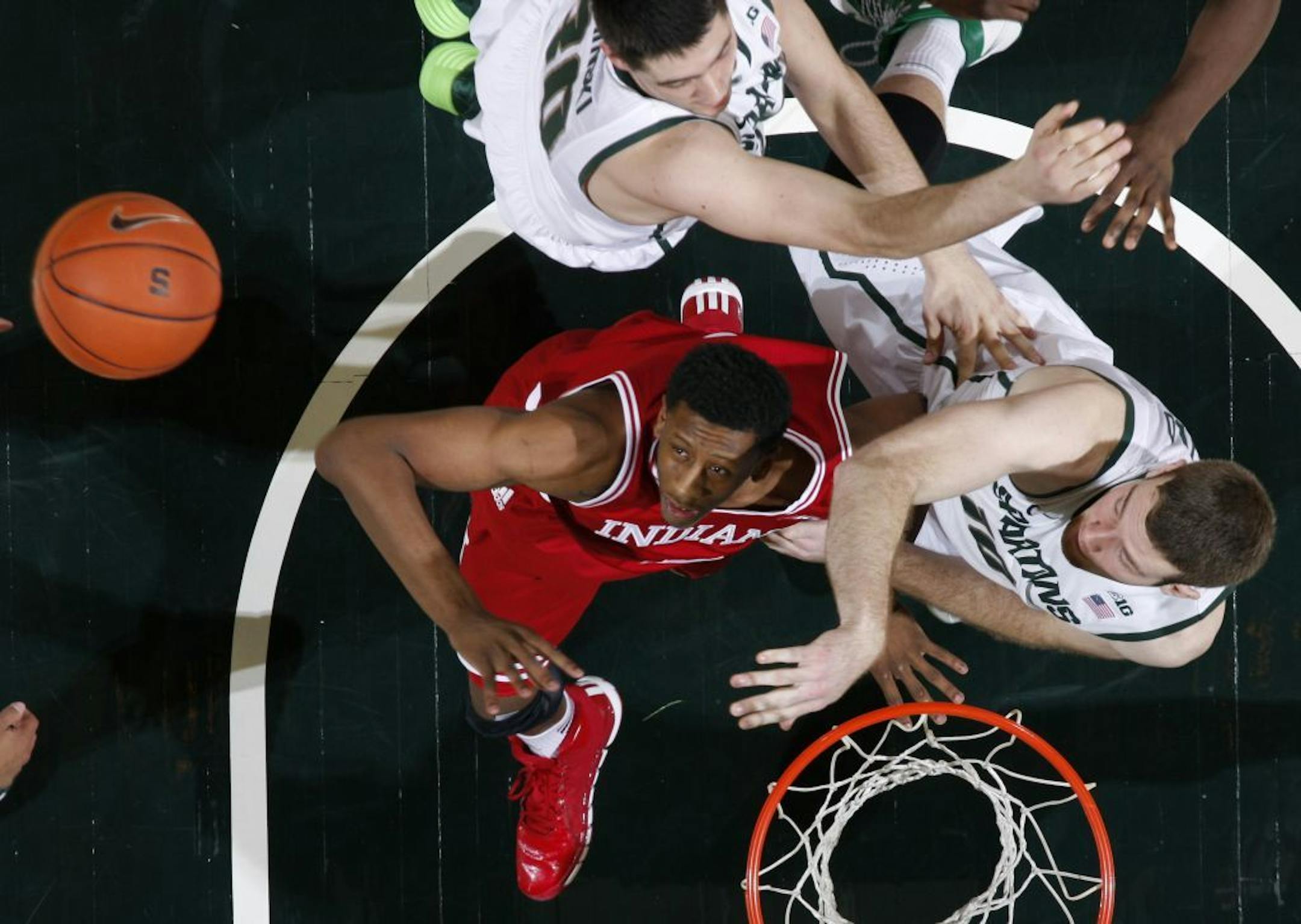 Indiana's Troy Williams, left, and Michigan State's Matt Costello, right, and Kenny Kaminski fight for position on rebound during the second half of an NCAA college basketball game, Tuesday, Jan. 21, 2014, in East Lansing, Mich. Michigan State won 71-66.