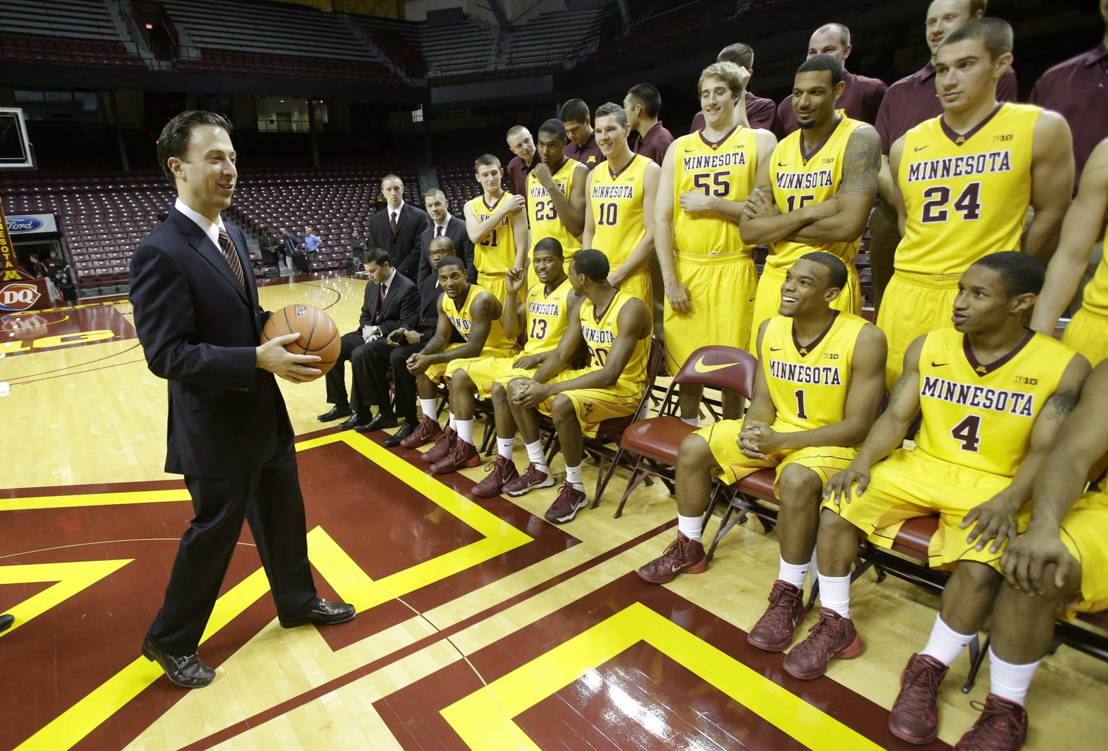 New Minnesota head basketball coach Richard Pitino, left, looks at his players before joining them for a team photo on media day atWilliams Arena.