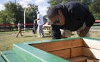 Asiaha Butler, executive director of the Resident Association of Greater Englewood, paints flower boxes Sept. 30, 2017, on a vacant lot in Chicago's E