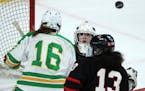 Eden Prairie goaltender Alexa Dobchuk (30) watched as the puck went over the head of her teammate Crystalyn Hengler (13) and Edina's Emily Oden (16) d