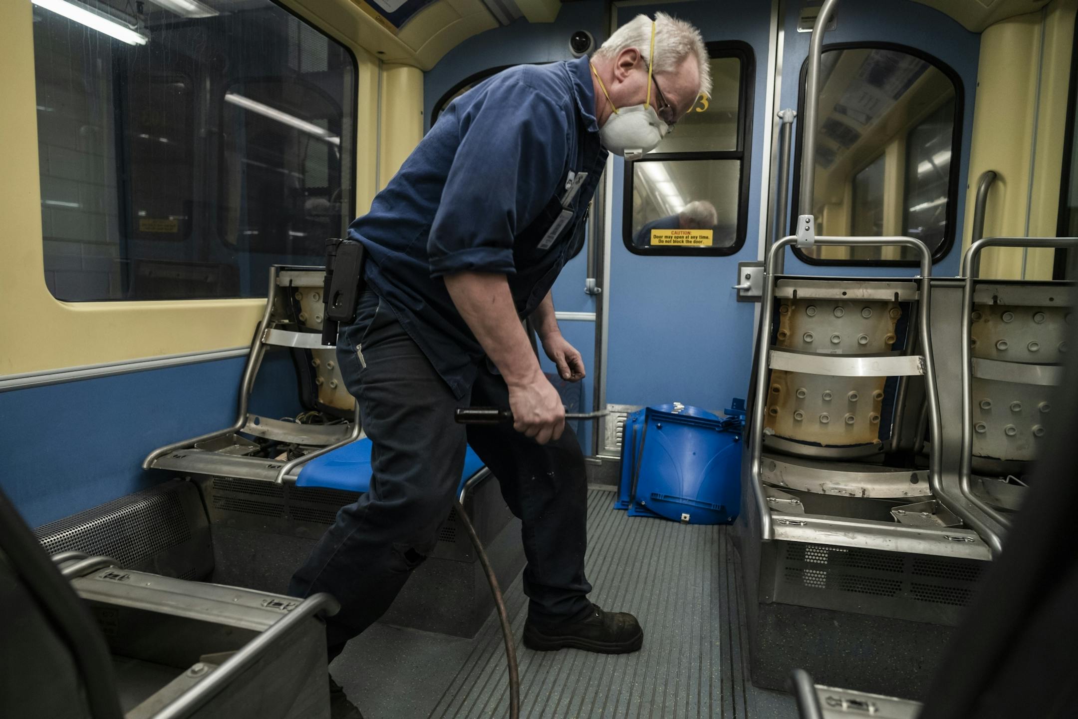 Electromechanical technician Timothy Malmstedt disassembled old cloth seats and installed new plastic seats as part of a test program to try seats that are easier to maintain.