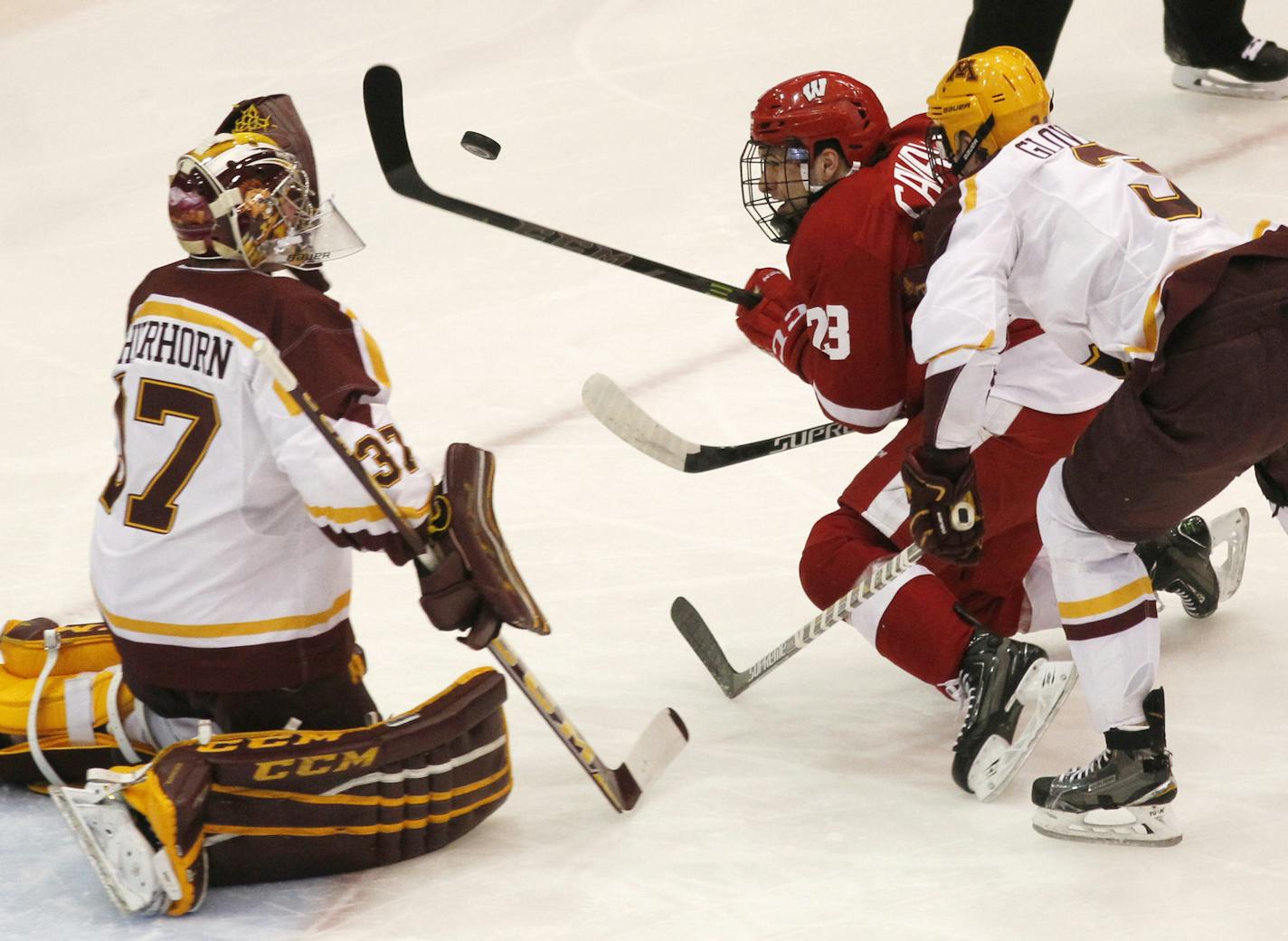 Wisconsin forward Aidan Cavallini (23) was denied by Gophers goalie Eric Schierhorn with help from defenseman Jack Glover on Friday.