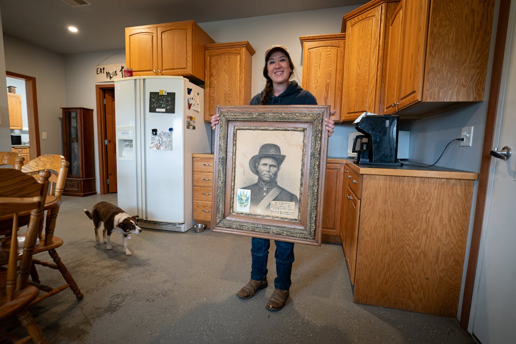 Erica Sawatzke with a photo of her great-great-great-grandfather Ole Sarsland at the family farm in Kensington, Minn. Sarsland homesteaded the farm in 1866.