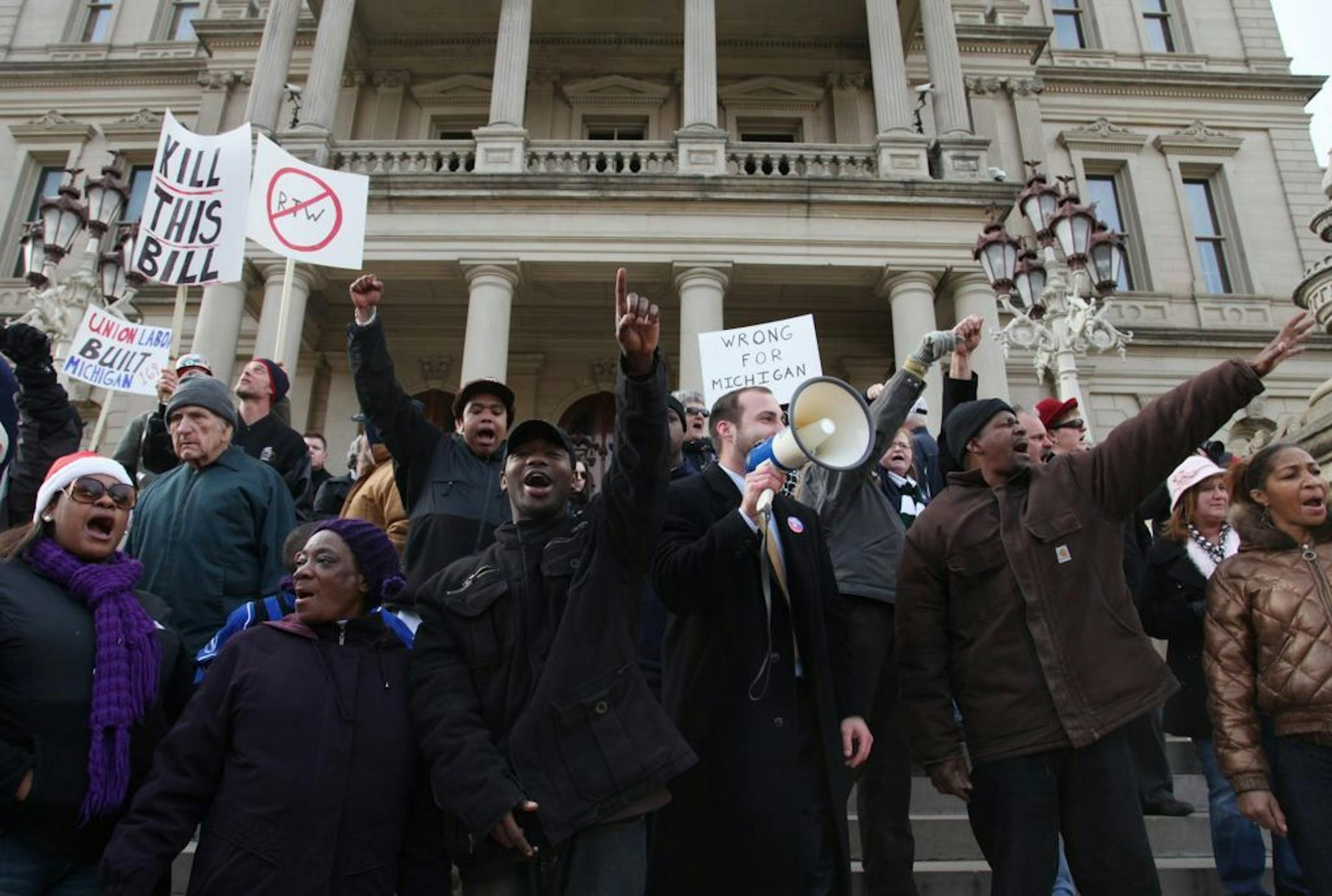 Protesters against "Right To Work" legislation chant "this is what democracy looks like" as they take to the steps of the Capitol in Lansing, Michigan, Thursday, December 6, 2012.