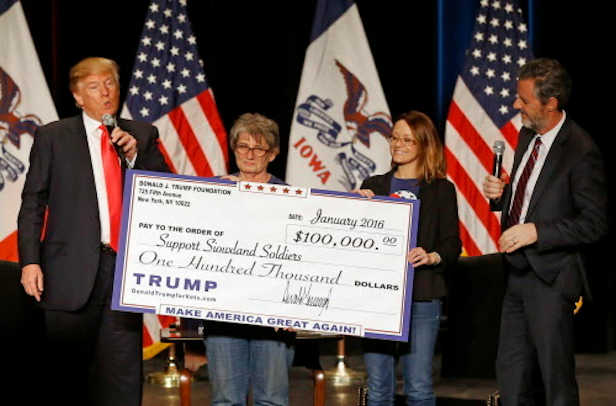 FILE - In this Jan. 31, 2016 file photo, Donald Trump, left, stages a check presentation with an enlarged copy of a $100,000 contribution from the Donald J. Trump Foundation to Support Siouxland Soldiers during a campaign event in Sioux City, Iowa., during Trump's run for president. The Foundation agreed to dissolve on Tuesday amid a legal battle with New York Attorney General Barbara Underwood. Also pictured is Jerry Falwell, Jr., right, president of Liberty University.
