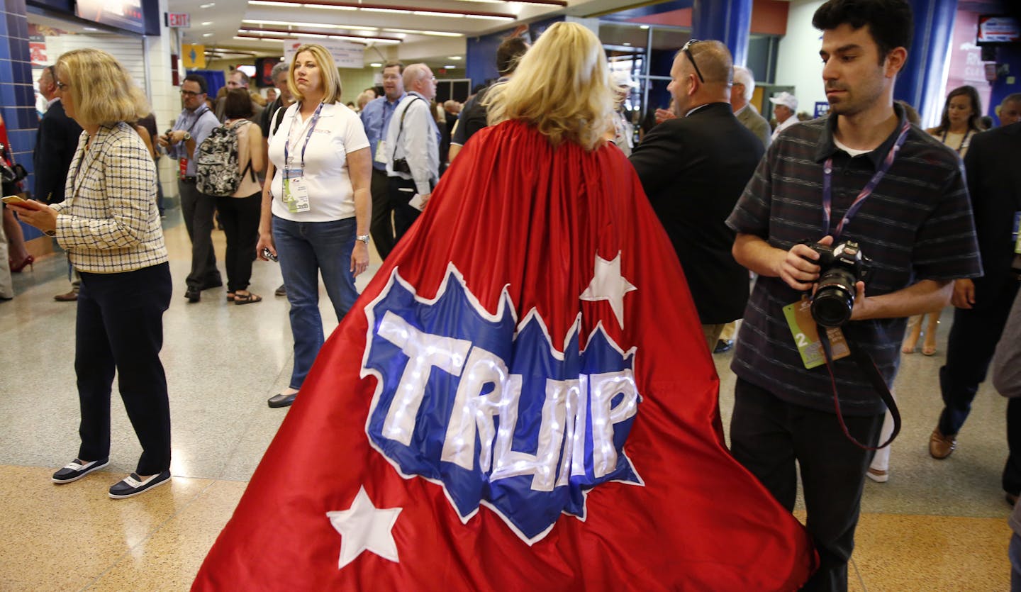 Minnesota delegate Mary Susan walks around the hallway in her Trump cape at Quicken Loans Arena before the start of the second day session of the Republican National Convention in Cleveland, Tuesday, July 19, 2016. (AP Photo/Matt Rourke)