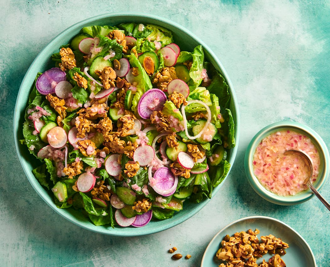 This Little Gem salad is topped with a shallot vinaigrette and savory granola. 