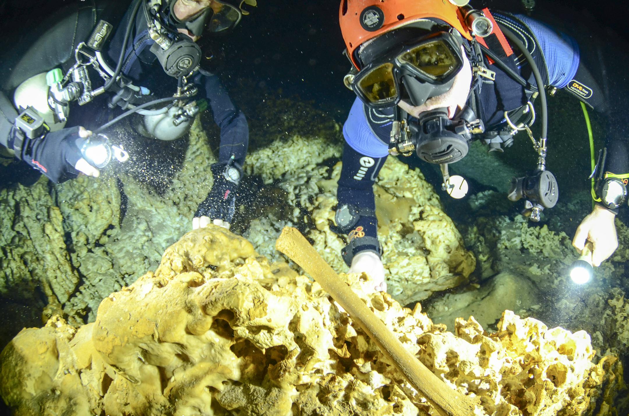 This undated photo released by Mexico's National Anthropology and History Institute (INAH), shows divers from the Great Mayan Aquifer project exploring the Sac Actun underwater cave system where Mayan and Pleistocene bones and cultural artifacts have been found submerged, near Tulum, Mexico. Mexican experts said Monday, Feb. 19, 2018, that the recently mapped Sac Actun cave system "is probably the most important underwater archaeological site in the world," but is threatened by pollution. (Jan A
