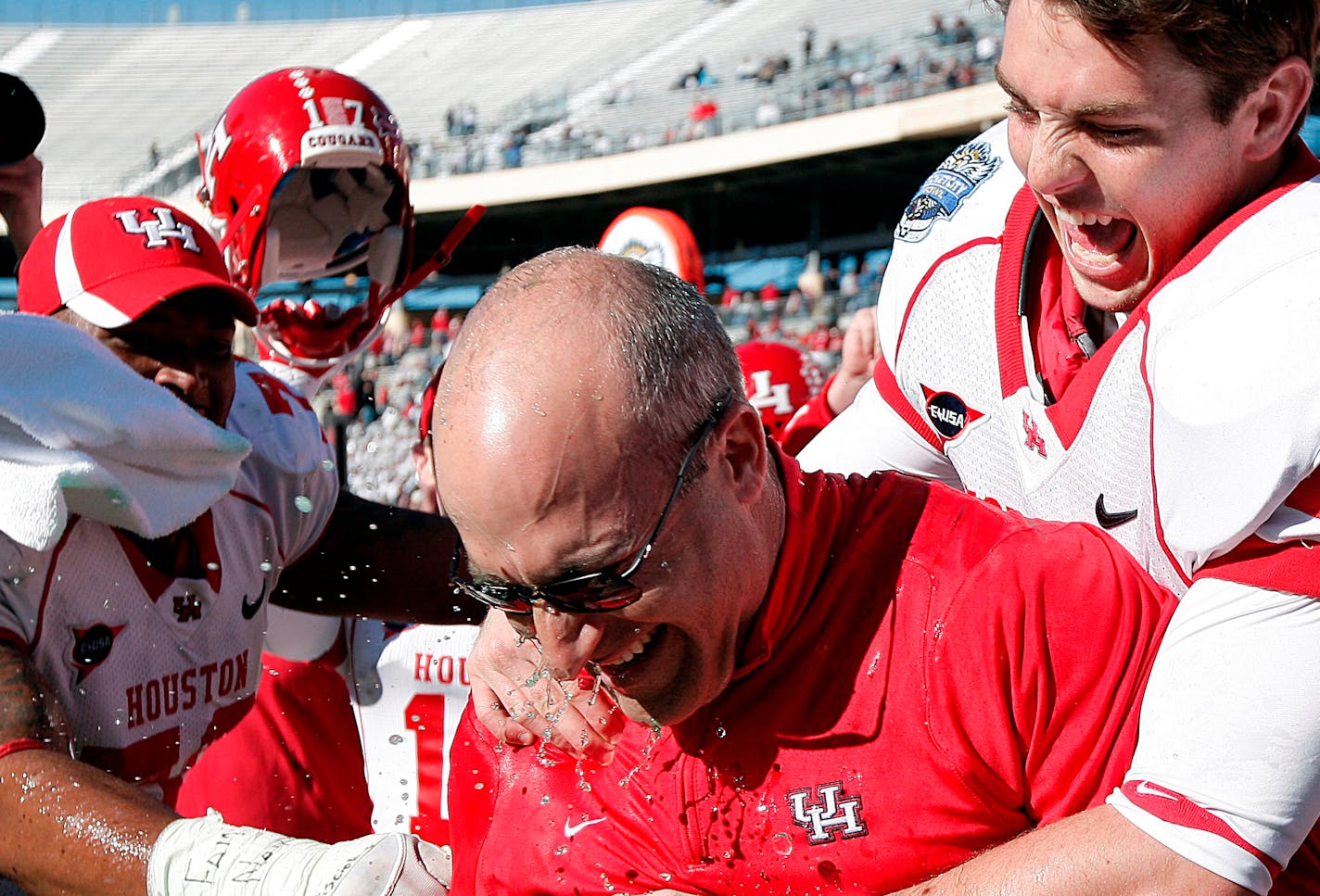 Houston head coach Tony Levine is congratulated by his team after defeating Penn State the in the TicketCity Bowl NCAA college football game, Monday, Jan. 2, 2012, at the Cotton Bowl in Dallas. Houston won 30-14. (AP Photo/Brandon Wade)