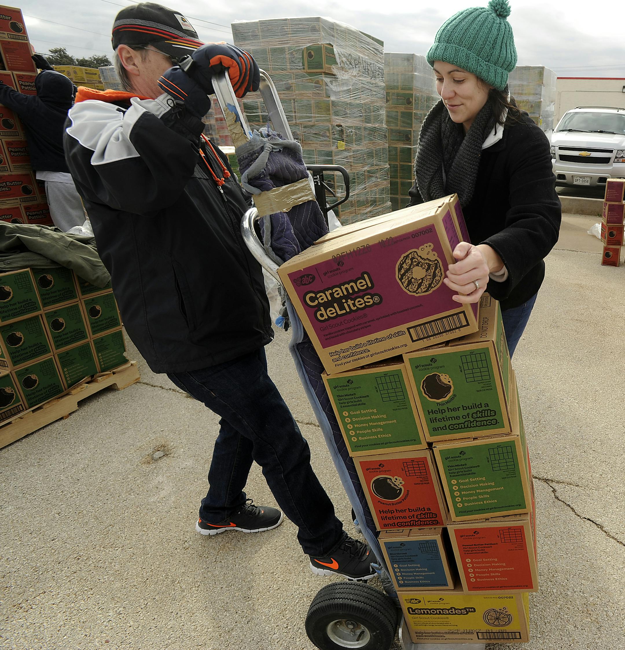 Michelle Lawson, center, area coordinator for the Girl Scouts, loads cases of Girl Scout cookies onto a hand truck in Abilene, Texas on Saturday, Jan. 16, 2016. (Tommy Metthe/Abilene Reporter-News via AP)