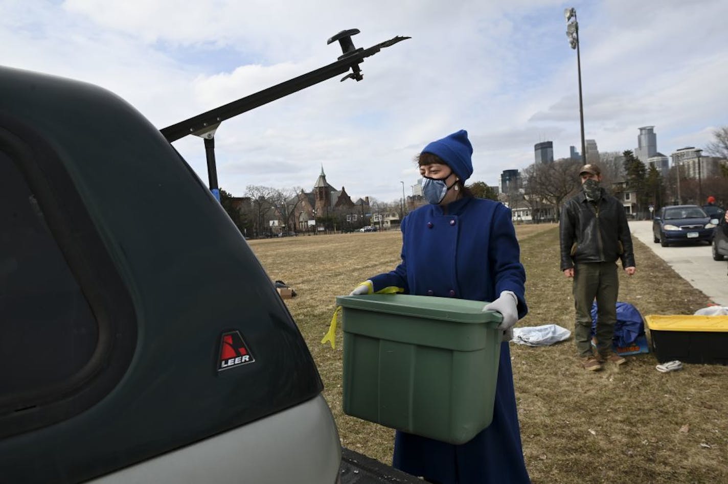 Emma Torzs, a volunteer with Anam Cara, lifted a box of supplies into the back of a pickup after helping distribute supplies, like food, tents and sleeping bags, to the homeless and vulnerable at Peavey Field Park Saturday.